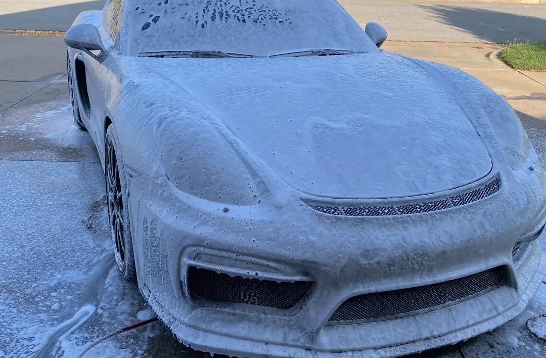 A car covered in snow foam during an exterior wash