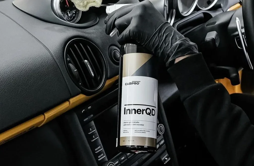 Interior detailing spray being applied to a vehicle dashboard